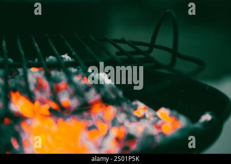 Schwelendes Holz auf einem Metallgrill. Grill im Freien. Gefährliches heißes orangenes Brennholz. Feuriges Feuer. Kochen Sie Essen auf heißen Kohlen draußen in der Natur. Stockfoto