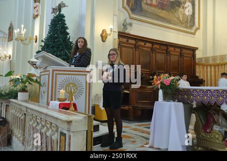 Das Licht des Friedens, das von Bethlehem kommt , wird den Gläubigen am Heiligabend dargebracht . Mädchen von Boyscout zünden die Kerze des Friedens an. Stockfoto