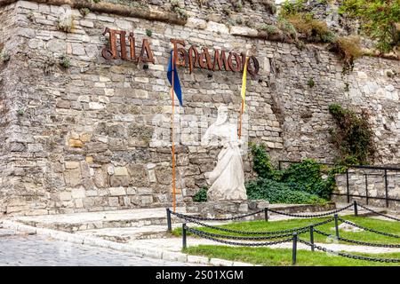 Eine Steinmauer mit einer Statue einer Frau, die ein Schwert hält, und einem Schild mit der Aufschrift „der Emergo“ Stockfoto