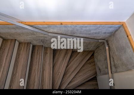 Ein Blick nach unten auf eine Treppe mit Metallgeländern entlang einer Betonwand Stockfoto