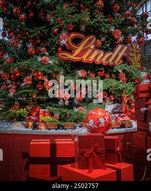Zürich, Schweiz - 24. November 2024: Ikonischer Lindt-Weihnachtsbaum am SBB Hauptbahnhof Zürich mit Weihnachtszug und Schokoladendekoration Stockfoto