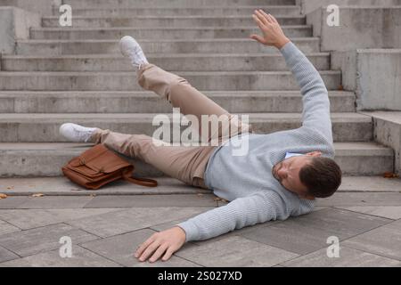 Verletzter Mann auf Treppen draußen nach dem Sturz. Gefährlicher Unfall Stockfoto