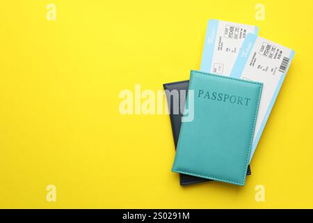 Reisebüro. Flugtickets und Pässe auf gelbem Hintergrund, Blick von oben. Leerzeichen für Text Stockfoto