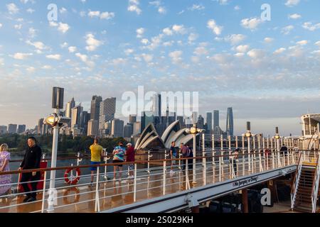 Das Kreuzfahrtschiff Cunard Queen Elizabeth kommt kurz nach Sonnenaufgang im Hafen von Sydney an, NSW, Australien, 2024 mit Passagieren an Deck, um die Stadt zu sehen Stockfoto
