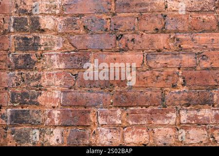 Antike Ziegelwand mit Überresten von bemalten Designs Stockfoto