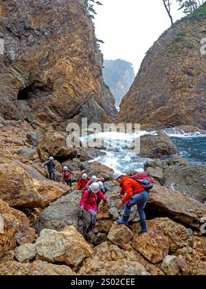 Wanderer unterhalb der Kitayamazaki Klippen auf dem Michinoku Coastal Trail Stockfoto