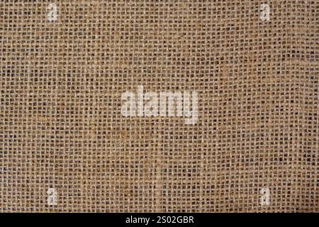 Nahaufnahme eines Sackleinen-Stoffes mit gewebter Textur und rustikalem Look, ideal als natürlicher Hintergrund oder Materialgestaltungselement. Stockfoto