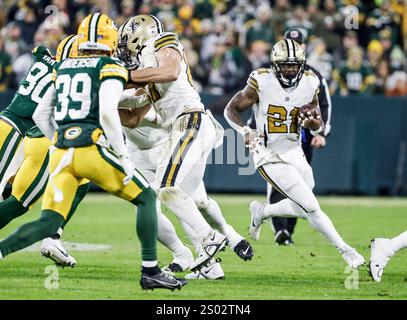 Green Bay, Usa. Dezember 2024. New Orleans Saints Running Back Jamaal Williams (R) folgt seinen Blockern, während er den Ball während des Spiels zwischen den New Orleans Saints und den Green Bay Packers im Lambeau Field in Green Bay, Wisconsin am Montag, den 23. Dezember 2024 trägt. Foto: Tannen Maury/UPI Credit: UPI/Alamy Live News Stockfoto