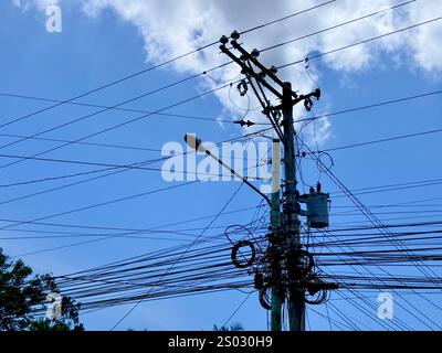 Komplexer Versorgungsmast mit Drähten gegen den blauen Himmel Stockfoto