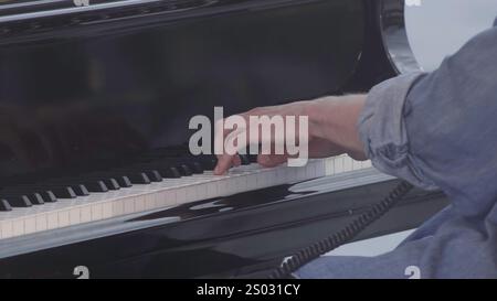 Die Hände der Pianisten kreieren auf einem wunderschönen Flügel fesselnde Melodien, die Kunstfertigkeit zeigen. Clip Stockfoto