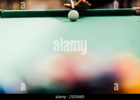 Ein Billardtisch mit verstreuten Billardbällen, einem Queuestift und Accessoires in einer dynamischen, spielbereiten Szene. Der detaillierte Fokus auf die Ausrüstung Stockfoto