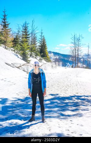 Eine Frau, die im Winter auf einem Bergweg zum Gipfel des Malinowska Skała klettert Stockfoto