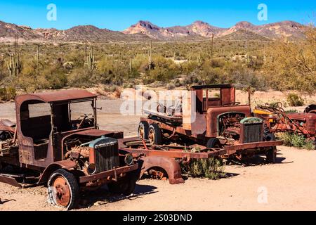Drei alte, verrostete Trucks stehen in einer Wüste. Die Lkw haben alle verschiedene Größen und Formen, aber sie alle haben ein ähnliches Aussehen. Die Szene ist q Stockfoto