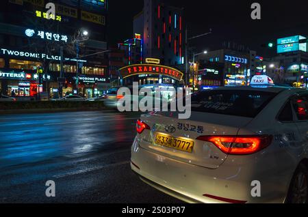 Busan, Südkorea - 19. März 2018: Nächtlicher Blick auf die Straße mit Rücksitz des weißen Taxiwagens Hyundai Solaris Stockfoto