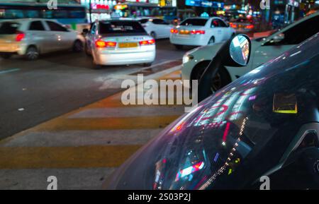 Busan, Südkorea - 23. März 2018: Nächtlicher Straßenblick mit Taxiautos und Reflexionen farbenfroher Neonwerbung Stockfoto