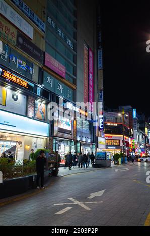 Busan, Südkorea - 23. März 2018: Vertikaler Blick auf die Straße bei Nacht mit farbenfroher Beleuchtung und Menschen, die die Straße in der Innenstadt erkunden Stockfoto