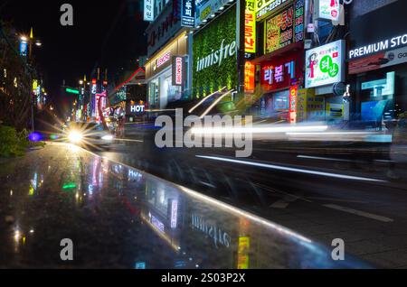 Busan, Südkorea - 23. März 2018: Nächtlicher Stadtblick mit heller Straßenwerbung Neonbeleuchtung und verschwommenen Autos Stockfoto