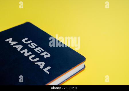 Nahaufnahme eines Benutzerhandbuchs auf hellgelbem Hintergrund. Leitfaden, Support, Tutorial-Konzept. Stockfoto