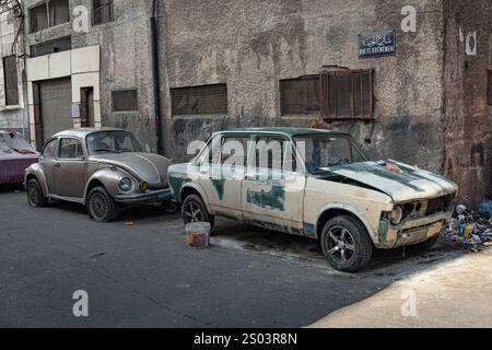 In der Alexandria Straße befindet sich ein altes Auto, das zum Anmalen vorbereitet wurde, neben einem alten Volkswagen Käfer. Die Szene zeigt urbane Handwerkskunst. Stockfoto