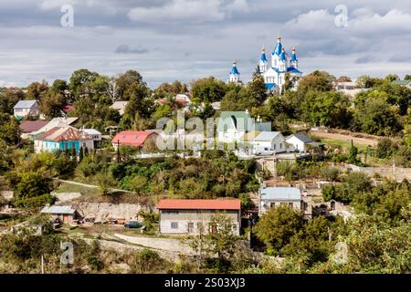 Eine kleine Stadt mit einer Kirche und Häusern. Die Häuser sind größtenteils weiß und die Kirche blau. Die Stadt ist von Bäumen umgeben und hat eine friedliche Atmosphäre Stockfoto