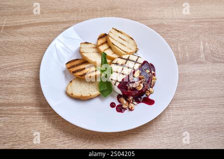 Gegrillter Camembert-Käse mit süßer Beerensauce, Walnüssen und geröstetem Brot. Stockfoto