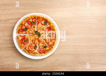 Klassische Margherita-Pizza mit Mozzarella, Tomaten und Basilikum, in Scheiben geschnitten. Stockfoto