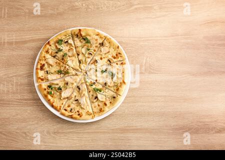 Pizza mit Hühnchen, Pilzen und cremiger Sauce, in Scheiben geschnitten. Stockfoto