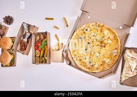 Eine Sammlung von Mahlzeiten zum Mitnehmen in Kartonschachteln mit Pizza, Burgern, Huhn und Gemüse. Stockfoto