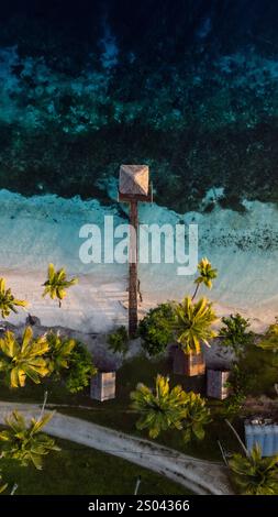 Tropischer Strand mit Pier und transparentem Meer. Reiseziel in Indonesien, vertikale Drohnenaufnahme Stockfoto