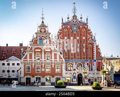 Ein historisches Gebäude mit kunstvoller Architektur mit roten Backsteinen und dekorativen Elementen, das sich auf einem Marktplatz befindet. Die Struktur zeigt komplizierte Details Stockfoto