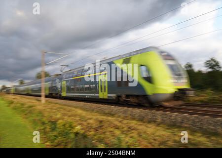 Ein moderner, grüner deutscher elektrischer Personenzug, der vorbeifährt Stockfoto