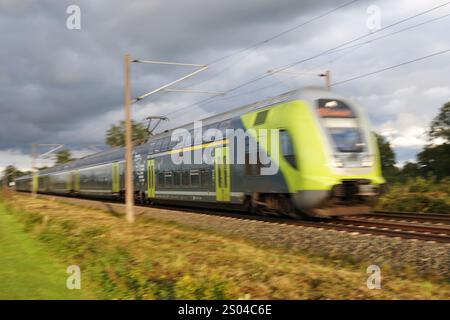 Ein moderner, grüner deutscher elektrischer Personenzug, der vorbeifährt Stockfoto