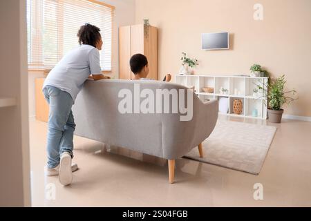 Niedliche afroamerikanische Kinder, die zu Hause Cartoons im Fernsehen anschauen, Rückansicht Stockfoto