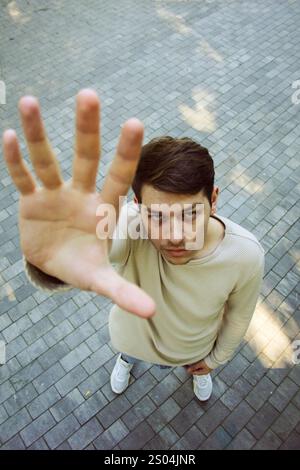 Von einem hohen Aussichtspunkt aus steht ein Mann auf einer kopfsteingepflasterten Straße. Die Ansicht unterstreicht seine Position in der belebten städtischen Umgebung. Das Stadtbild ist noch besser Stockfoto