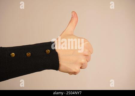 Ein gedrückter Daumen sendet eine klare Botschaft der Ermutigung und Bestätigung aus. Die allgemein verstandene „ähnliche“ Geste ist kühn und doch einfach. Das ist minimalistisch Stockfoto