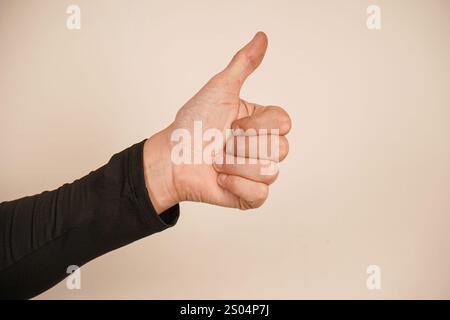 Ein gedrückter Daumen sendet eine klare Botschaft der Ermutigung und Bestätigung aus. Die allgemein verstandene „ähnliche“ Geste ist kühn und doch einfach. Das ist minimalistisch Stockfoto