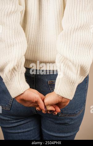 Zwei Hände greifen ihre Finger zu einer geschlossenen Haltung. Diese kraftvolle Geste zeigt Solidarität und Engagement. Vor neutralem Hintergrund, t Stockfoto