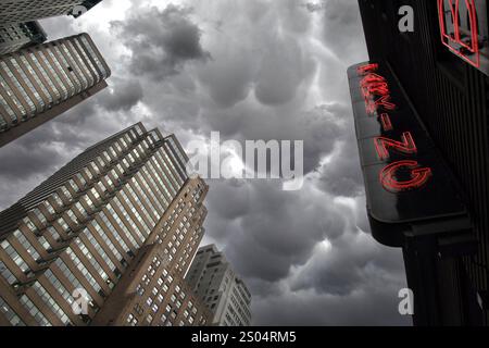 Dramatische Sturmwolken über Wolkenkratzern mit beleuchtetem rotem Neon-Parkschild Battery Parking Garage im Battery Park manhattan, New york City Stockfoto