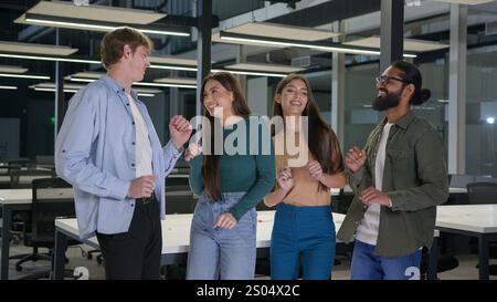 Glückliche multiethnische Geschäftsmänner Geschäftsfrauen tanzen zusammen im Büro Arbeitsplatz Unternehmen fröhlich fröhlich gemischt Team Männer Frauen Kollegen Kollegen Stockfoto