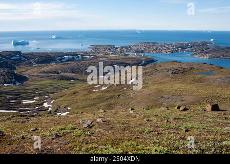 Dieses atemberaubende Bild fängt den Sommerblick von Qeqertarsuaq auf Disko Island in Grönland von einem nahe gelegenen Berg ein. Das Dorf ist Nest gesehen Stockfoto