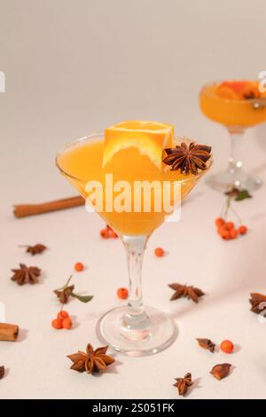 Orangensaft im hohen Glas mit Orangenwürfel und Gewürzen Stockfoto