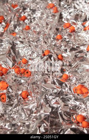 Hintergrund der zerknitterten Aluminiumfolie und des verstreuten Feuerstachels Stockfoto