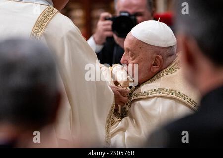 Vatikan, Vatikan. Dezember 2024. Papst Franziskus küsst die Statue des Jesuskindes während der Heiligabend-Messe. Der Papst eröffnete das Heilige Jahr offiziell mit dem Ritus der Öffnung der Heiligen Pforte der Päpstlichen Basilika St. Peter am 24. Dezember um 19:00 Uhr. (Foto: Stefano Costantino/SOPA Images/SIPA USA) Credit: SIPA USA/Alamy Live News Stockfoto