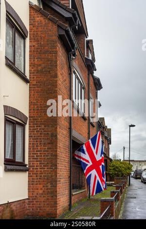 Große britische Union Jack Flagge hängt von einem Balkon in einer Wohnstraße in Südengland, Großbritannien Stockfoto