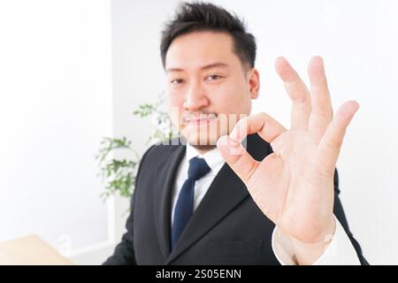 Geschäftsmann unterschreibt das OK-Zeichen Stockfoto