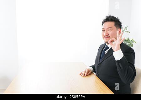 Geschäftsmann unterschreibt das OK-Zeichen Stockfoto