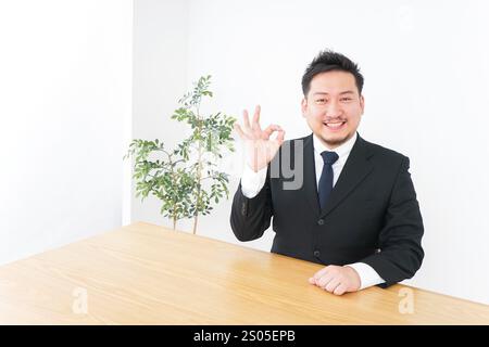 Geschäftsmann unterschreibt das OK-Zeichen Stockfoto