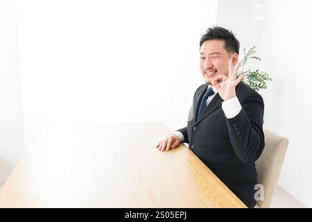 Geschäftsmann unterschreibt das OK-Zeichen Stockfoto