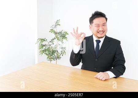 Geschäftsmann unterschreibt das OK-Zeichen Stockfoto
