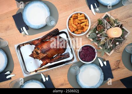 Gänsebraten zum Weihnachtsfest Blick auf einen festlich gedeckten Tisch. Im Mittelpunkt steht der Gänsebraten. Der Ursprung dieses Gänsebratens geht auf die Martinsgans zurück, die oft am Gedenktag des hl. Martin, noch vor Beginn des Advents gegessen wurde. Der Advent hatte früher den Charakter einer Fastenzeit. Mit der Christmette endete diese, und so wurde eine Gans als Festtagsbraten zubereitet. Leer Niedersachsen Deutschland *** Gänsenbraten zu Weihnachten Blick auf einen festlich gedeckten Tisch der Fokus liegt auf Gänsenbraten der Ursprung dieser Gänsebraten geht auf die St. Martins-Gans zurück, die oft vorkam Stockfoto